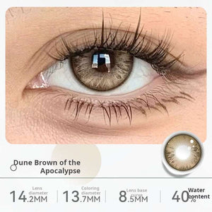 Close-up of an eye wearing "Dune Brown of the Apocalypse" contact lenses, showing a natural light brown shade. Specifications: 14.2mm diameter, 13.2mm graphic diameter, 8.5mm base curve, 40% water content.