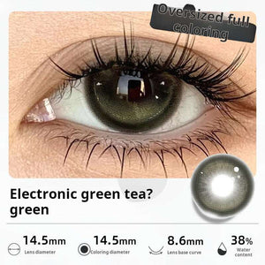 Close-up of an eye wearing "Electronic green tea? green" contact lenses, displaying a deep, subtle green tone. Specifications: 14.5mm diameter, 14.5mm graphic diameter, 8.6mm base curve, 38% water content.
