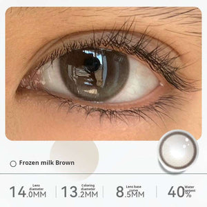 Close-up of an eye wearing "Frozen milk Brown" contact lenses, displaying a light, creamy hazel tone. Specifications: 14.0mm diameter, 13.1mm graphic diameter, 8.5mm base curve, 40% water content.