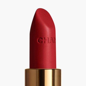 Detailed close-up of a CHANEL Rouge Allure Velvet lipstick bullet with embossed logo.