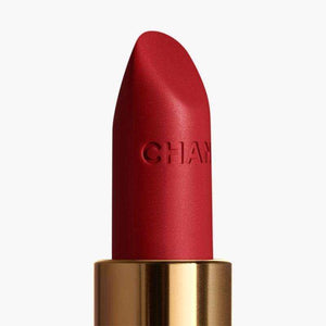 Detailed close-up of a CHANEL Rouge Allure Velvet lipstick bullet with embossed logo.