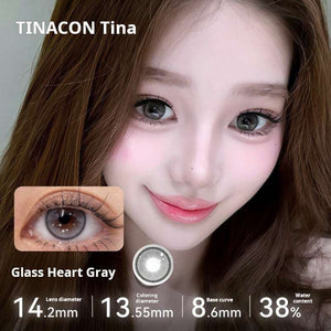 Close-up of an eye wearing Glass Heart Gray lenses, featuring a glossy, reflective light gray shade. Specs: 14.2mm diameter, 13.55mm graphic diameter, 8.6mm base curve, 38% water content.