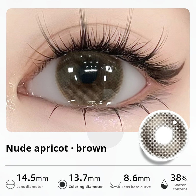 Close-up of an eye wearing "Nude apricot - brown" contact lenses, showing a soft, natural dark brown tint. Specifications: 14.5mm diameter, 13.7mm graphic diameter, 8.6mm base curve, 38% water content.