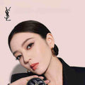 YSL Cushion Foundation luxury compact held by elegant woman with flawless glowing skin and minimal makeup on beige background