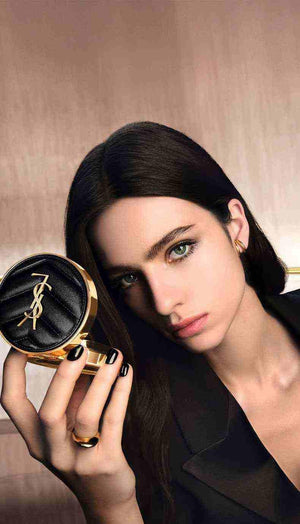 Elegant woman holding YSL Cushion Foundation compact showcasing luxury makeup product with natural radiant finish